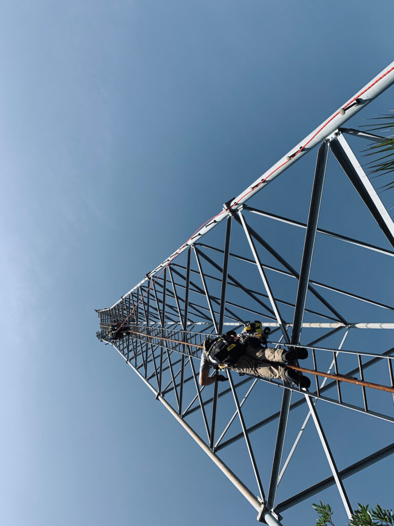 Engineers climb a tower structure